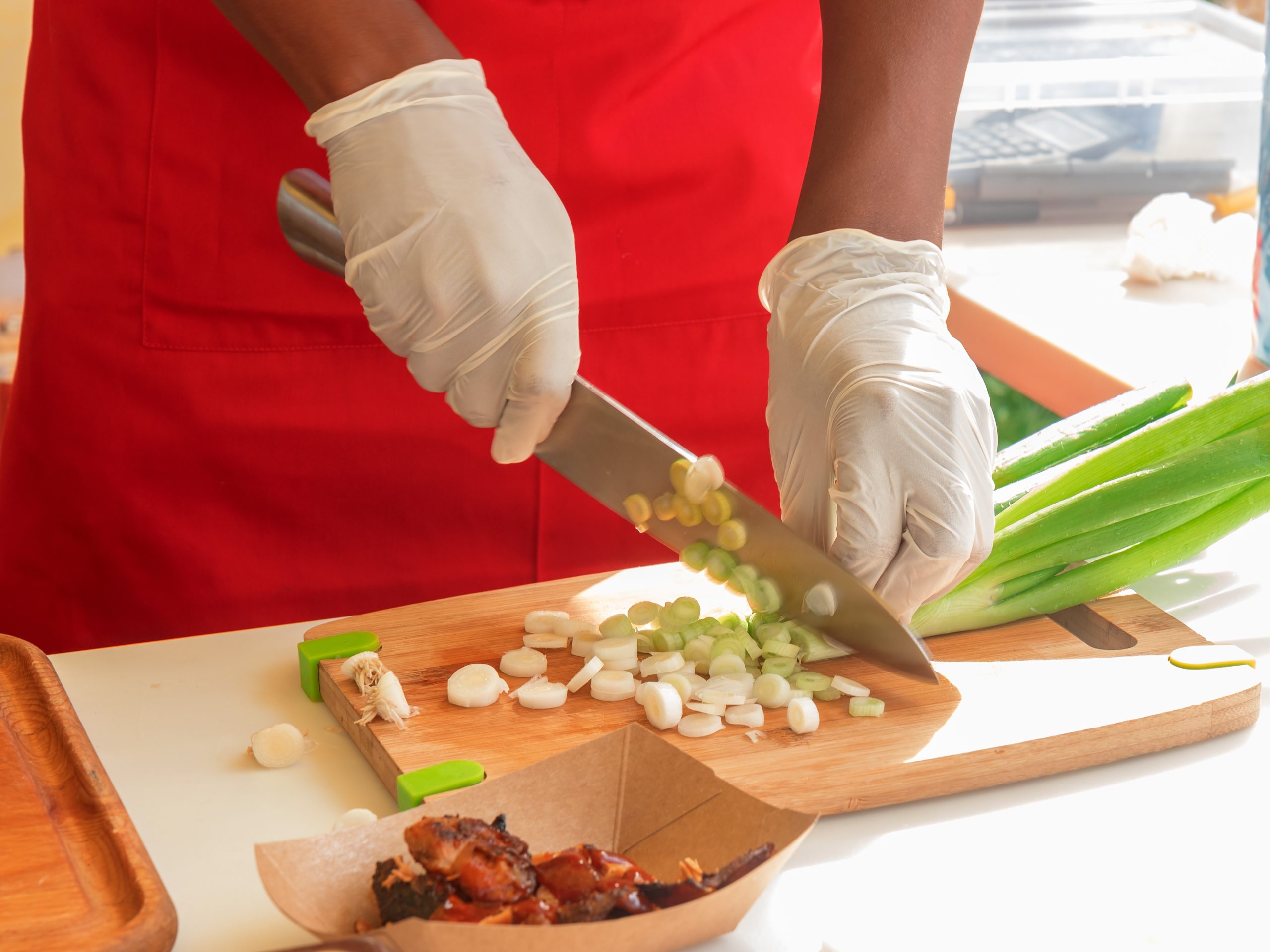 Chef using knife to cut green onions
